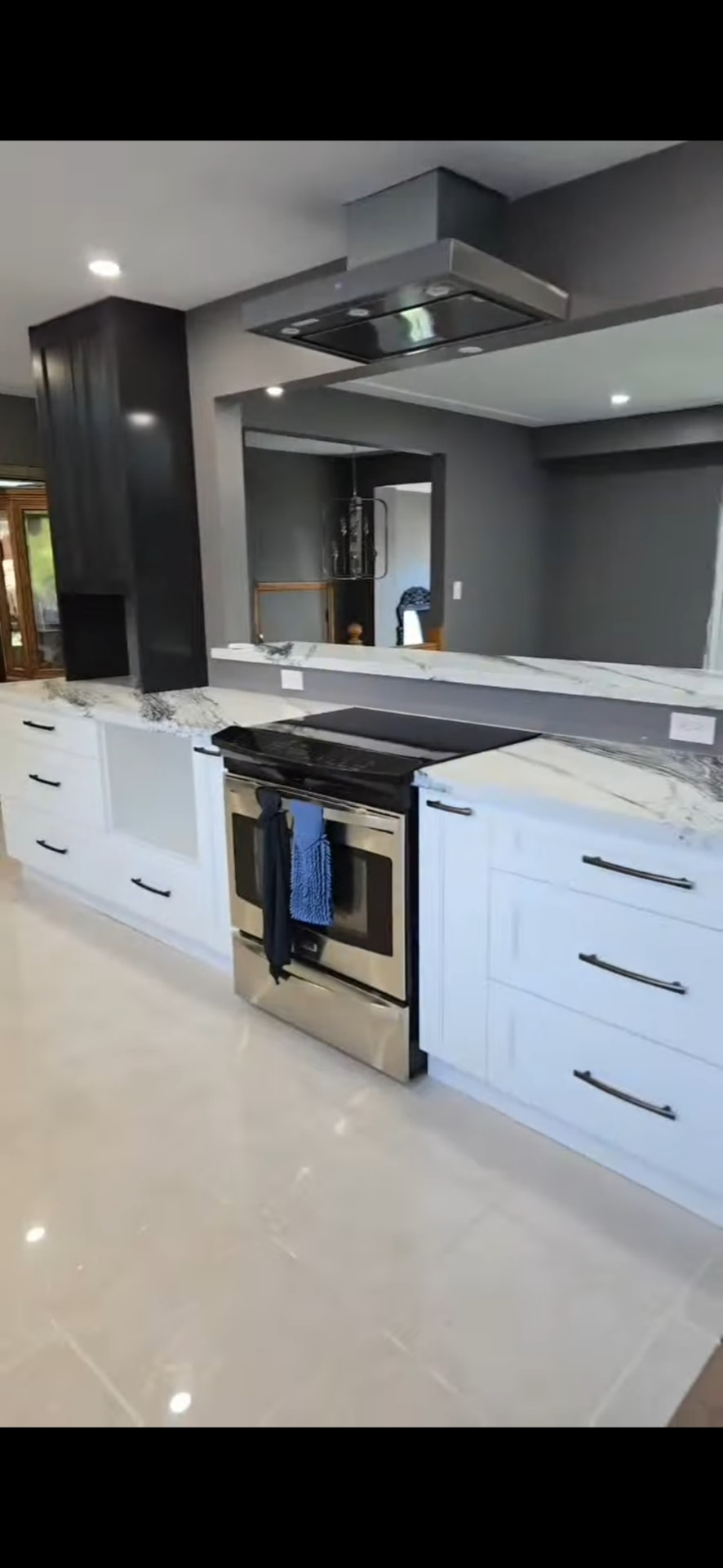 Finished kitchen range wall with black chimney hood and matte black hardware