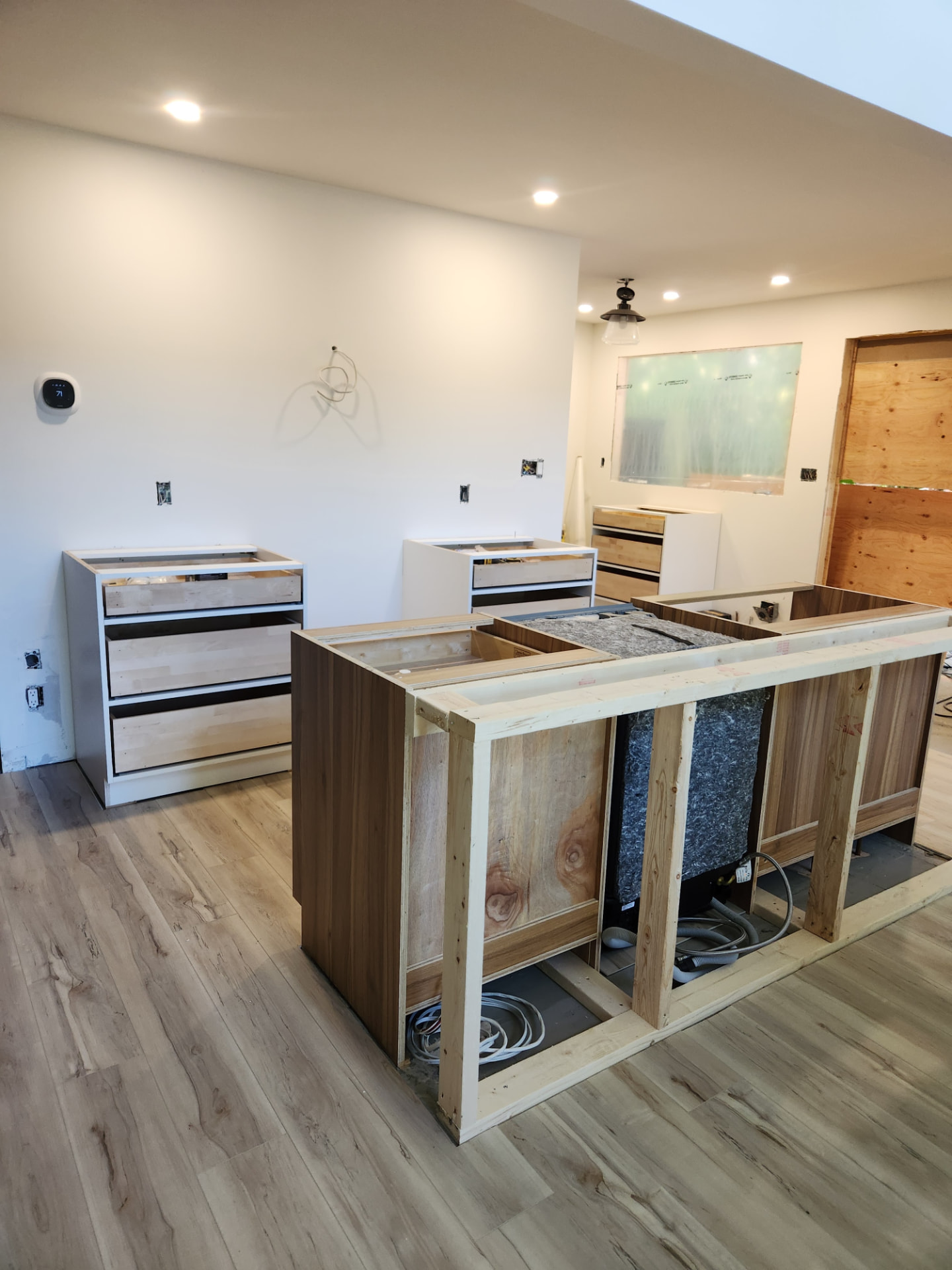 Base cabinets and the framed walnut island under construction