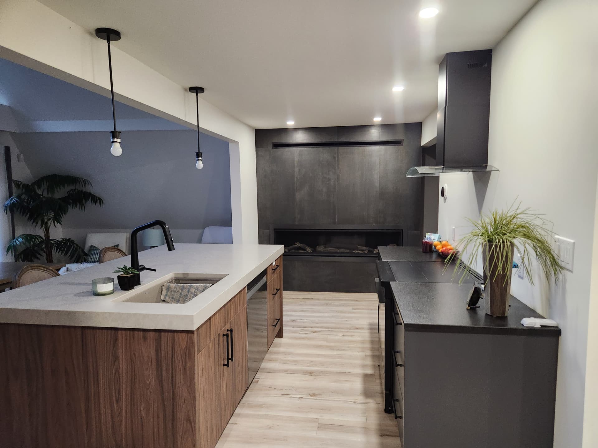 Finished kitchen looking toward the linear fireplace with large-format dark tile surround